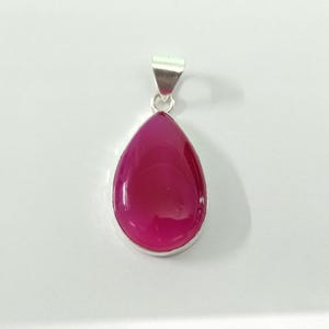 May include: A silver pendant featuring a teardrop-shaped pink agate gemstone.