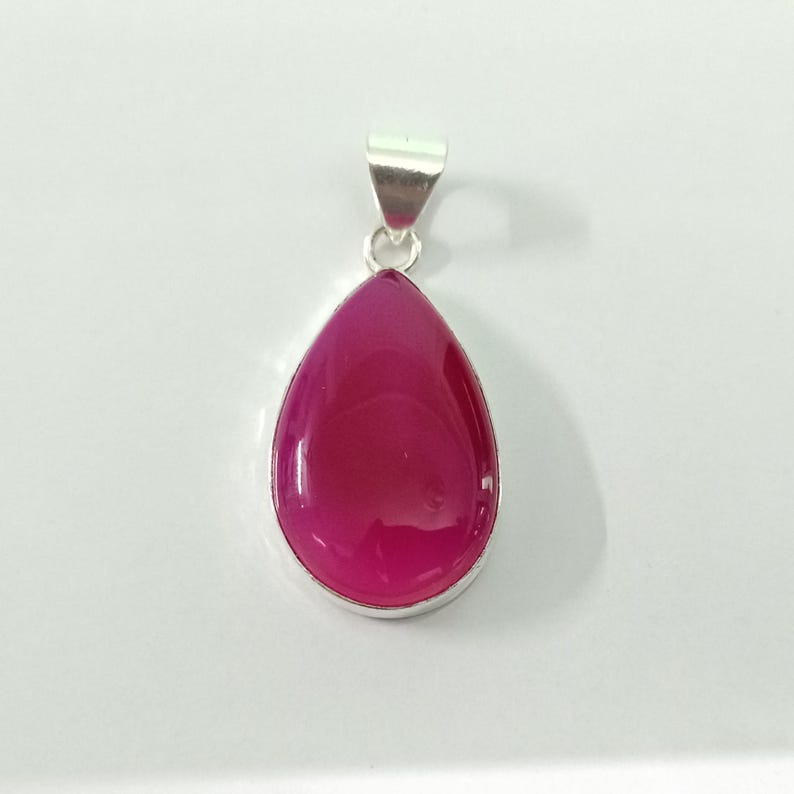 May include: A silver pendant featuring a teardrop-shaped pink agate gemstone.