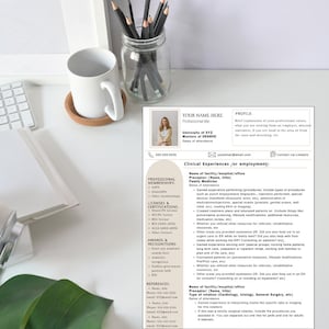 Könnte beinhalten: Eine Lebenslaufvorlage mit Foto, Kontaktdaten und Abschnitten für Berufserfahrung, Mitgliedschaften, Lizenzen und Referenzen. Der Lebenslauf liegt auf einer weißen Oberfläche mit einer weißen Tasse, einem Untersetzer und Bleistiften in einem Glas.