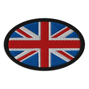 May include: An oval-shaped embroidered patch featuring the Union Jack flag design. The patch displays a central red cross with white borders, set against a blue background, all enclosed within a thick, solid black stitched border edge.
