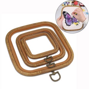 May include: Set of three square embroidery hoops with a wood-grain finish. The hoops are nested, with a metal clasp and ring closure. A smaller inset image shows a butterfly embroidery project in progress.