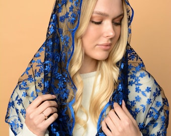 May include: A sheer black veil with intricate blue floral embroidery. The veil is draped over the head and shoulders, creating a delicate and elegant look. The blue embroidery provides a striking contrast against the black fabric.