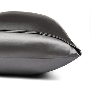 May include: A charcoal gray satin pillowcase with a smooth, silky texture.