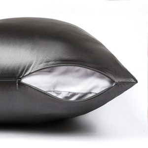 May include: A charcoal gray satin pillowcase with a zipper closure. The pillowcase is made of soft, luxurious fabric.