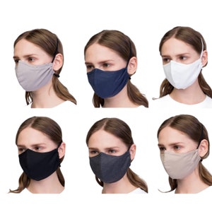 May include: Six different color face masks made of a soft, breathable fabric. The masks are shown on six different models with the same hairstyle and pose. The masks are all the same style, with a curved shape and adjustable ear loops.