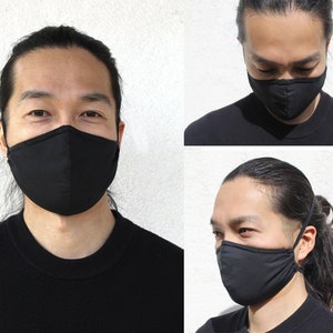 May include: Three people wearing black face masks. The masks are made of a soft, breathable fabric and have a simple, modern design.