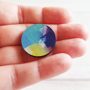 Small blue round wooden pin badge