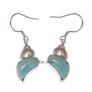 May include: Sterling silver earrings featuring a light blue sea glass shell design. The earrings have a delicate, feminine look.
