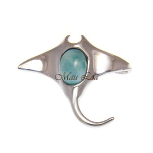 May include: A silver manta ray pendant with a light blue gemstone. The pendant is on a white background. "Maui Loa" is written on the pendant.
