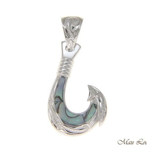 May include: Sterling silver pendant featuring a traditional Hawaiian fish hook design with abalone inlay. The hook is intricately detailed with a floral pattern and a polished finish.