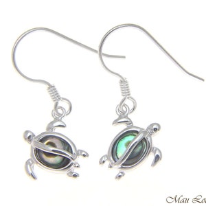 May include: Sterling silver earrings featuring a turtle design with a green abalone shell inlay. The earrings have a hook closure.