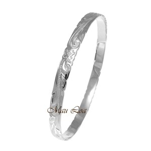 May include: A silver bangle bracelet with a floral design. The bracelet is made of polished silver and has a smooth, shiny finish.