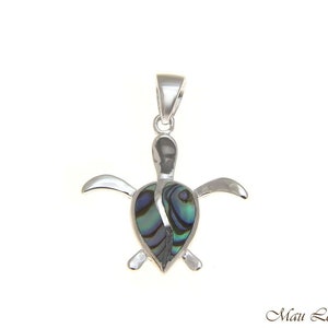May include: Silver turtle pendant with a green, blue, and purple abalone shell inlay. The pendant is on a white background.