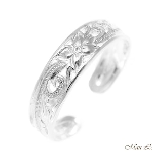 Può includere: Un anello per dita dei piedi color argento con un design aperto. L'anello presenta incisioni floreali e di foglie dettagliate sulla fascia. L'anello è posto su uno sfondo bianco.