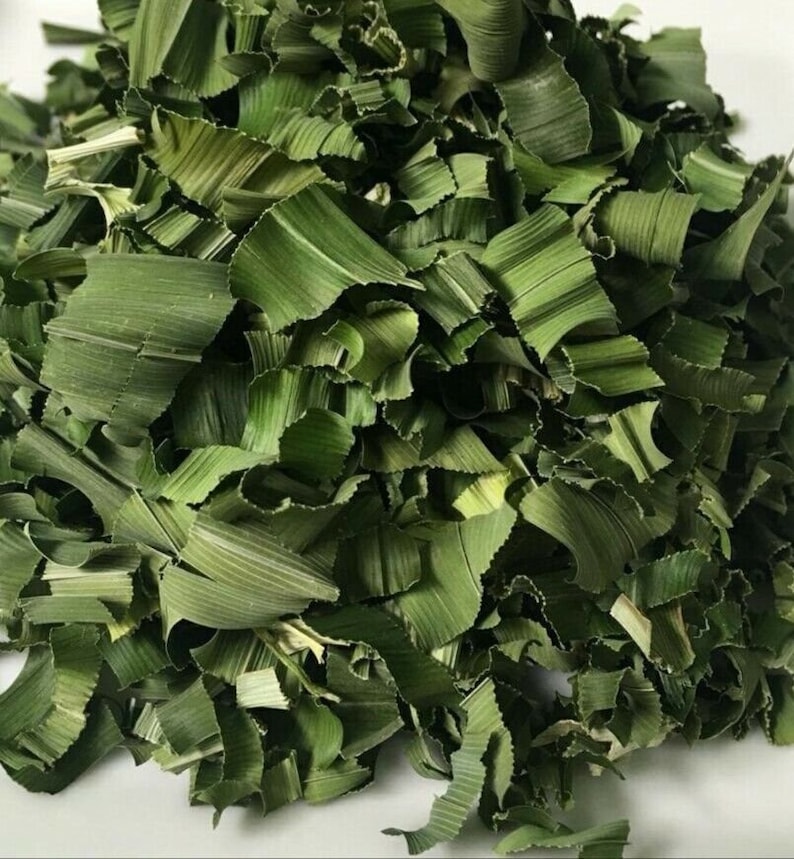 May include: Close-up of dried, chopped green pandan leaves. The leaves are a vibrant green color and have a textured appearance. The image shows a pile of the leaves, which are commonly used in Southeast Asian cuisine for flavoring and coloring.
