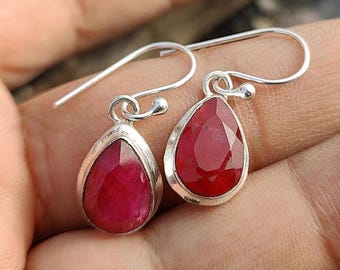 Peut inclure: Une paire de boucles d'oreilles pendantes en argent avec des pierres précieuses en rubis rouge en forme de goutte.