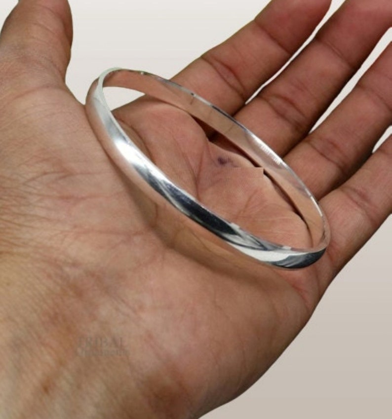 May include: A silver bangle bracelet with a smooth, polished finish.