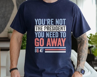 May include: A navy blue t-shirt with the text "You're not the president you need to go away 86 47" in white and red lettering.