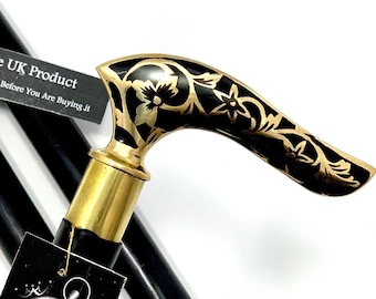May include: A black walking stick with a gold-colored handle featuring a floral design. The handle is curved and has a black and gold floral pattern. The stick is made of wood and has a gold-colored tip. The stick is accompanied by a tag that reads "Exclusive UK Product" and "Ministry of Antiques UK Seller Same Day Dispatch".