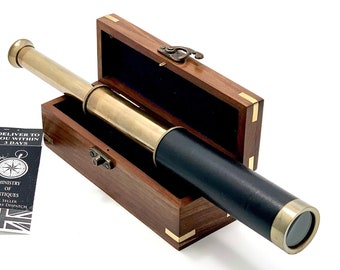 May include: A brass telescope with a black leather covering and a wooden box. The box has a brass latch and is open to reveal the telescope inside.