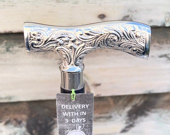 May include: A silver walking stick with an ornate handle and a black shaft. The handle has a floral design. A tag attached to the stick reads "DELIVERY WITHIN 3 DAYS" and "MINISTRY OF ANTIQUES UK SELLER SAME DAY DISPATCH".