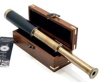 May include: A brass telescope with a black leather covering and a wooden box. The telescope is about 12 inches long and has a brass finish. The box is made of dark wood and has a brass latch.