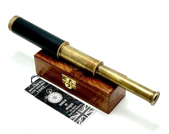 May include: A brass telescope with a black leather grip, in a wooden box with a brass latch. The box has a label that says "Ministry of Antiques" and a compass design.
