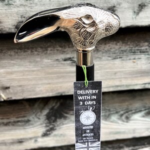 May include: A silver walking stick with a rabbit head handle. The stick has a black shaft and a tag that says "Delivery within 3 days".