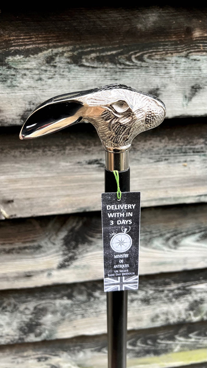 May include: A silver walking stick with a rabbit head handle. The stick has a black shaft and a tag that says "Delivery within 3 days".