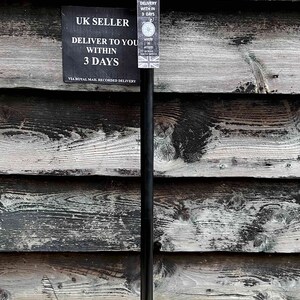 May include: A black walking stick with a silver rabbit head handle. The stick is standing upright against a wooden wall. A sign reads "UK SELLER DELIVER TO YOU WITHIN 3 DAYS VIA ROYAL MAIL RECORDED DELIVERY".