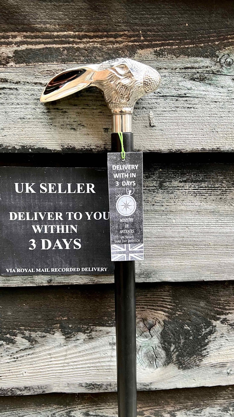 May include: A silver rabbit head walking stick with a black shaft. The stick has a tag attached that says "Delivery within 3 days" and "Ministry of Antiques UK Seller Same Day Dispatch".