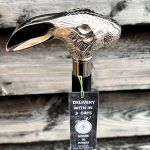 May include: A silver rabbit head walking stick with a black shaft. The stick has a tag attached that says "Delivery within 3 days" and "Ministry of Antiques".