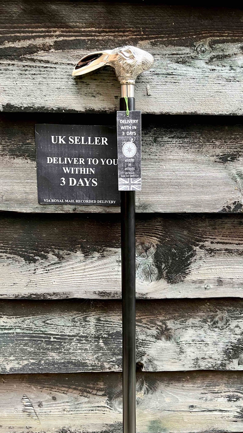 May include: A black walking stick with a silver rabbit head handle. The stick has a tag attached that says "UK Seller Deliver to you within 3 days via Royal Mail Recorded Delivery".