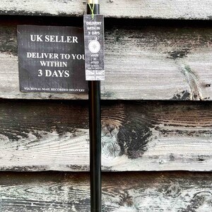 K&ouml;nnte beinhalten: Ein schwarzer Gehstock mit einem silbernen Griff. Der Griff hat ein dekoratives Design. Der Stock lehnt an einer Holzwand. Der Text auf dem Schild lautet "UK Seller Deliver to you within 3 days via Royal Mail Recorded Delivery".