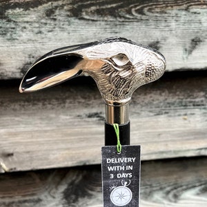 May include: A silver rabbit head walking stick with a black shaft. The stick has a tag that says "Delivery within 3 days".
