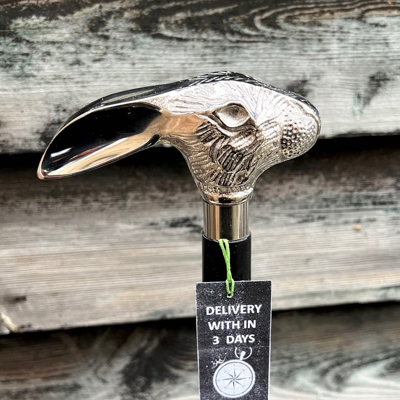 May include: A silver rabbit head walking stick with a black shaft. The stick has a tag that says "Delivery within 3 days".