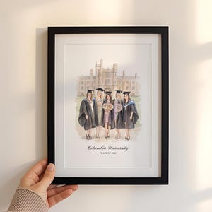 Könnte beinhalten: Ein gerahmter Aquarelldruck mit einer Gruppe von Absolventen in Hüten und Roben vor einem Universitätsgebäude. Der Druck befindet sich in einem schwarzen Rahmen und enthält den Text "Columbia University CLASS OF 2020".