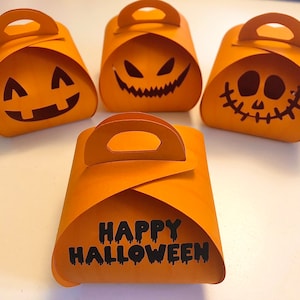 May include: Four orange pumpkin-shaped gift boxes with different Halloween designs. One box says "Happy Halloween" in black lettering.