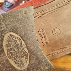 May include: Close-up of the bottom of a brown leather shoe with a brown rubber sole. The sole has a pattern of small triangles and the text "Made in Italy Elastomeree" is printed on the side. The shoe size is 41.