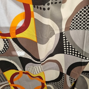 Op de afbeelding: Abstracte geometrische stof met een patroon van zwarte, witte, grijze, oranje en rode cirkels en krommen.
