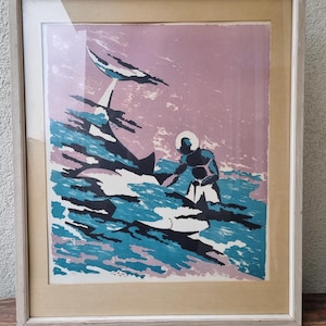 May include: A framed vintage print of a diver and a shark in a stylized abstract style. The print is in shades of blue, black, white, and pink.