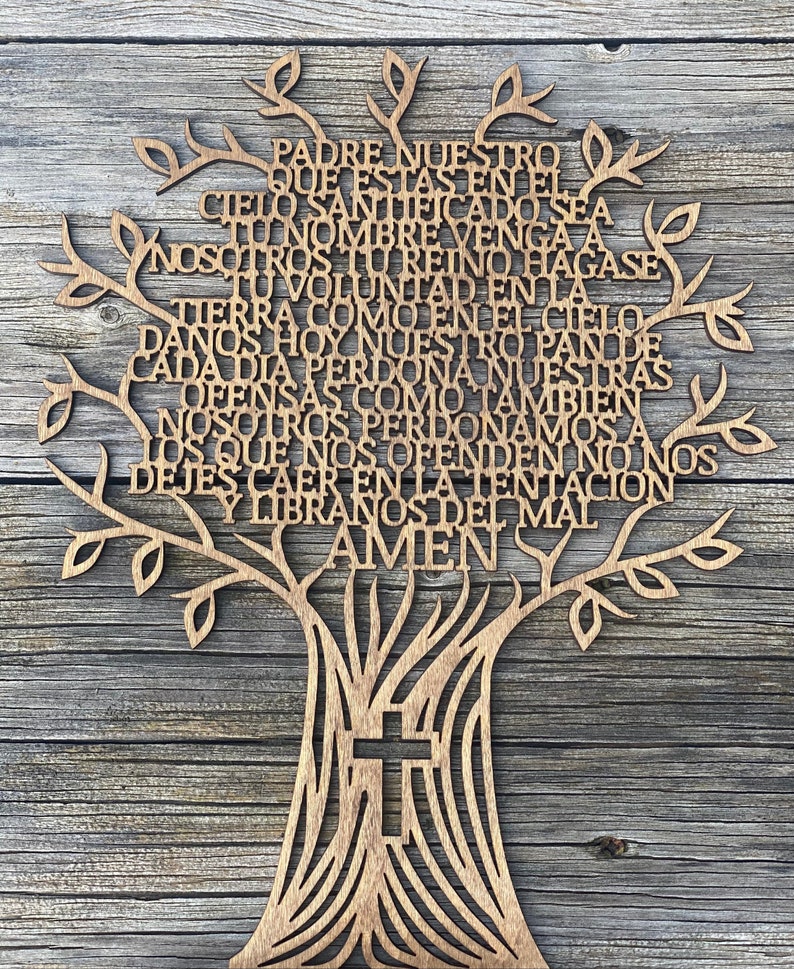 Puede incluir: Un &aacute;rbol de madera recortado con la oraci&oacute;n del Se&ntilde;or en espa&ntilde;ol, "Padre Nuestro", escrita en las ramas. El tronco del &aacute;rbol tiene una cruz tallada.