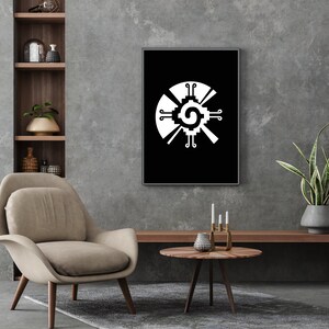 May include: A black and white print of the Aztec calendar, also known as the Sun Stone, in a black frame. The print is hanging on a gray wall above a wooden shelf and a brown armchair.