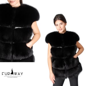 Könnte beinhalten: Eine schwarze Pelz-Weste mit ärmellosem Design und Reißverschluss. Die Weste hat einen mehrschichtigen Look mit mehreren Reihen aus Pelz.