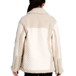 May include: A white quilted jacket with a sherpa collar and trim. The jacket has a chevron pattern on the front and back.