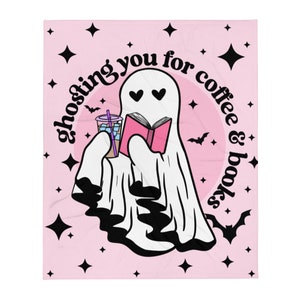 Peut inclure: Un fantôme rose et blanc aux yeux en forme de cœur tient un livre rose et une tasse de café glacé. Le fantôme est entouré d'étoiles noires et de chauves-souris sur un fond rose. Le texte "ghosting you for coffee & books" est écrit en noir autour du fantôme.