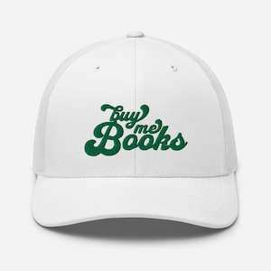 May include: White trucker hat with a green embroidered design that says "Buy Me Books" in a retro font.