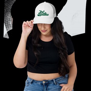 May include: White trucker hat with a green and white logo that says "Buy me Books".