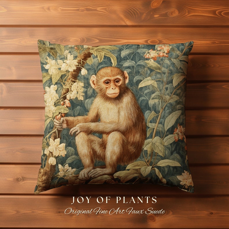 Pode incluir: Uma almofada decorativa com uma ilustra&ccedil;&atilde;o vintage de um macaco sentado em um ambiente de selva exuberante. A almofada apresenta um fundo azul com folhagem verde, flores brancas e um macaco marrom. O texto "JOY OF PLANTS" e "Original Fine Art Faux Suede" est&aacute; impresso abaixo da imagem.