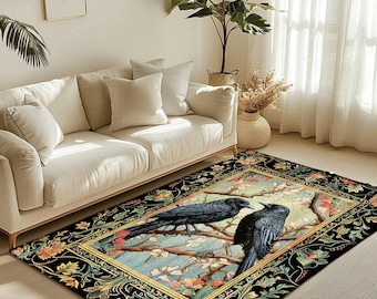 Op de afbeelding: Rechthoekig vloerkleed met twee zwarte kraaien op een tak met witte bloesems. Het kleed heeft een zwarte rand met bloempatronen en een goudkleurige binnenrand. De tekst "JOY OF PLANTS Original Fine Art Rugs" is zichtbaar.